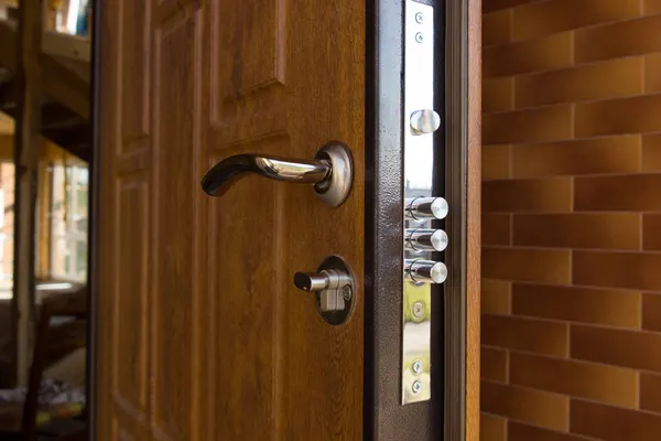 Serrure multipoints à trois pênes sur une porte d'entrée en bois